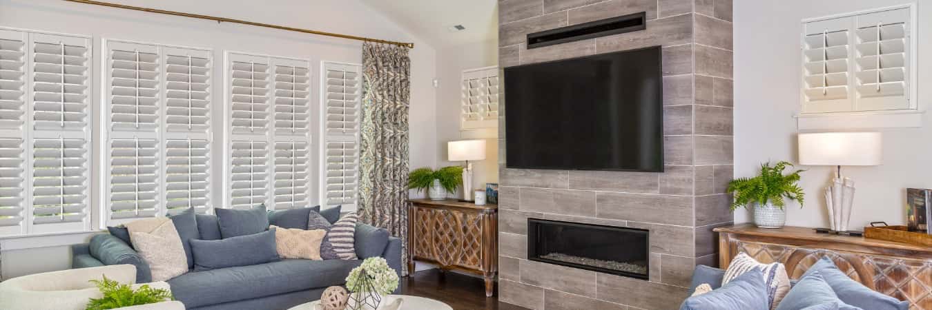 Interior shutters in Larchmont family room with fireplace