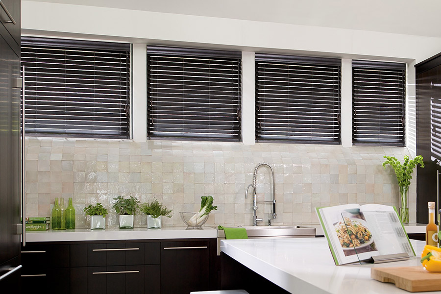 Choose custom Polywood faux wood blinds for your kitchen in New York. Special shaped faux wood blinds in several windows above a sink.