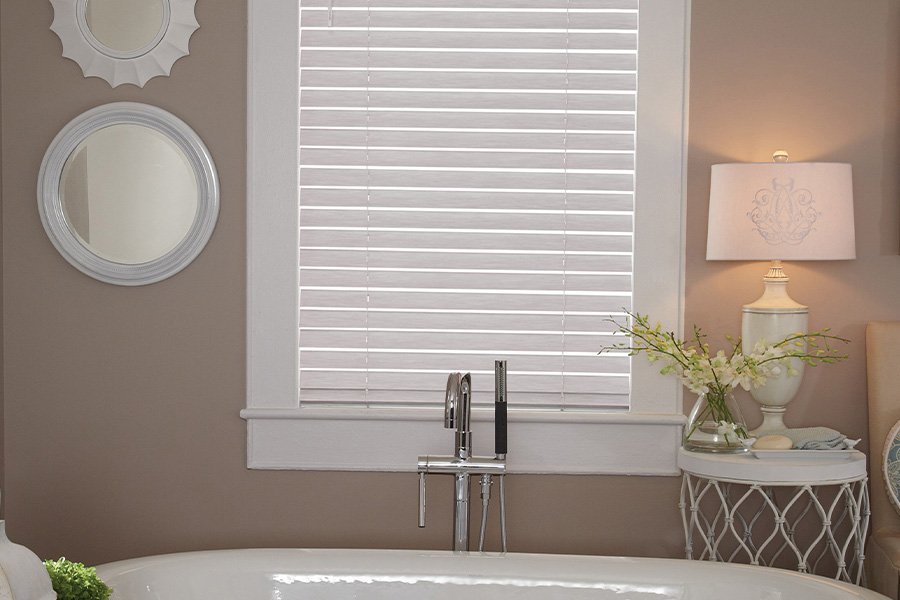 white faux wood blinds over bathtub