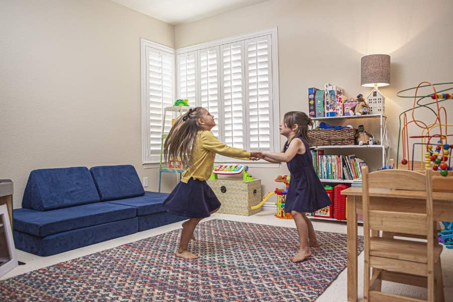 Choose Polywood shutters for durable, kid-friendly great room window treatments in New York. Polywood shutters on multiple windows in a sitting area
