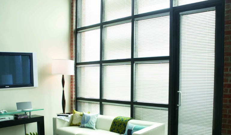 Traditional blinds can become tangled, misshapen, and faded. Metal Blinds in a living room.