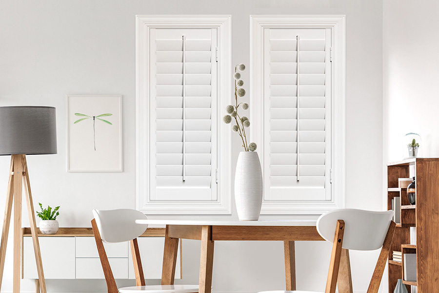 Sunburst's selection of stylish window treatments for designers in New York makes it easy to find the perfect ones for every design job.  White Polywood shutters on two windows in a modern Scandinavian-style room