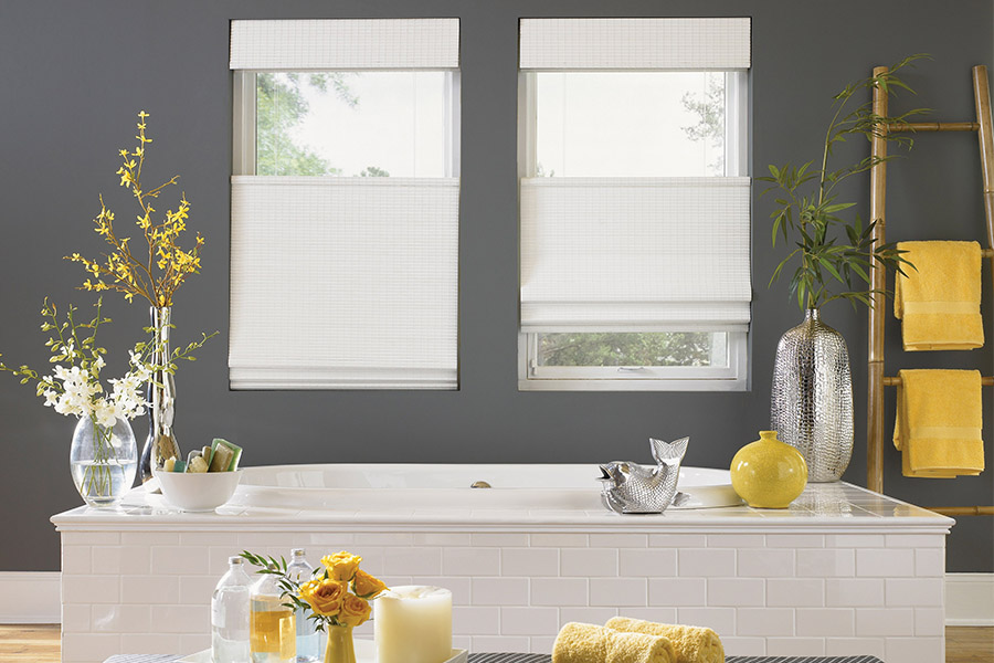 Find window shades your clients love among our many styles. White top-down/bottom-up window shades on two windows in a gray bathroom with yellow accents