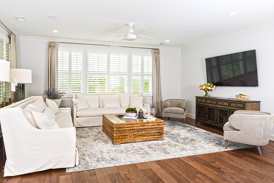 White Polywood shutters plus comfortable couches equals a beautiful media room. Large media room with white Polywood shutters.