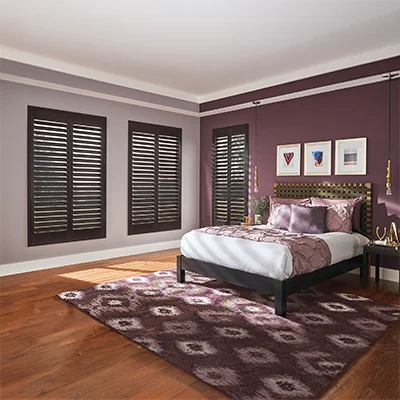 Dark brown ovation shutters in a corner of a bedroom