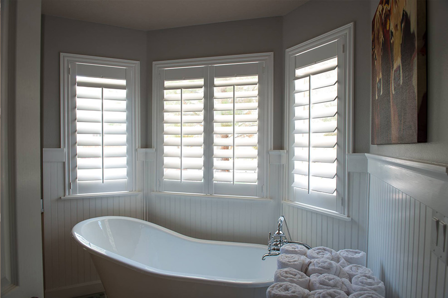Water-resistant,durable, and beautiful Polywood Shutters White Polywood shutters above a clawfoot white tub